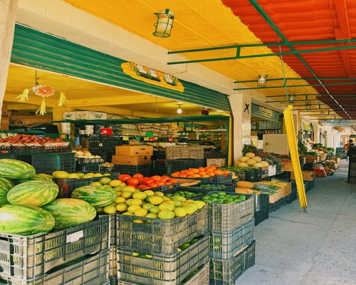 A vibrant Mexican market stall with fresh vegetables and fruits